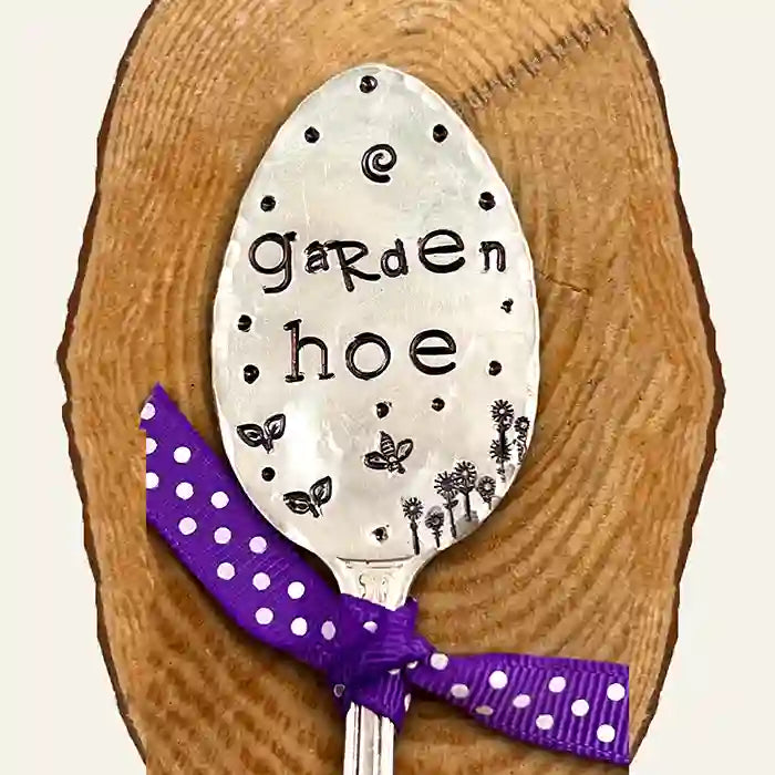 Garden Hoe flattened silver-plate spoon garden marker on wood background