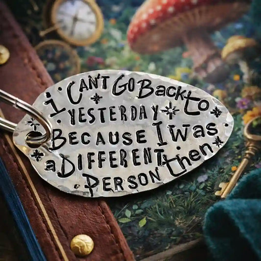 Metal keychain with engraved text on a fantasy-themed background