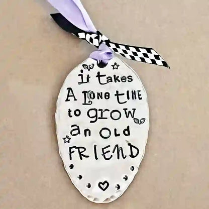 It Takes A Long Time To Grow An Old Friend vintage silver-plate silverware spoon ornament on tan background