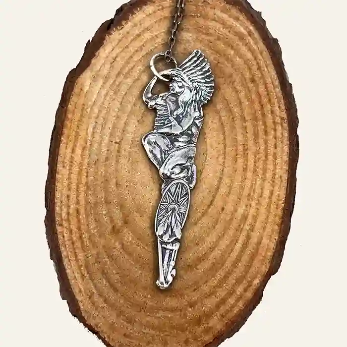 Silver-plate pendant of a stylized Native American figure made from a vintage souvenir spoon handle on wood