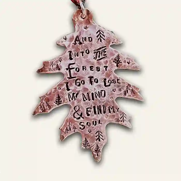 And Into The Forest I Go To Lose MY Mind & Find My Soul stamped into leaf-shaped copper ornament shining bright
