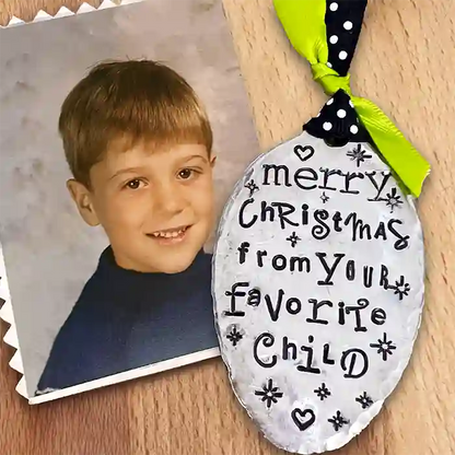 Vintage silver-plate spoon ornament with 'Merry Christmas from your favorite child' stamped text next to a photo of a young boy.

