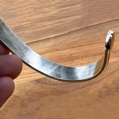 Inside of Sterling Silver bangle bracelet with three bands on wood background