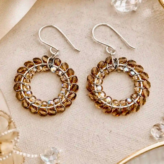 Pair of beaded hoop earrings on a textured surface