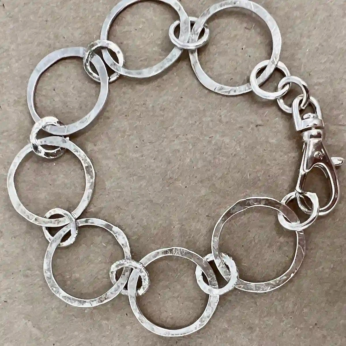 Silver chain bracelet on a textured beige background