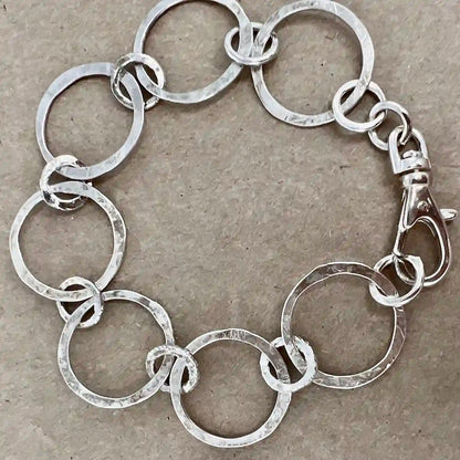 Silver chain bracelet on a textured beige background